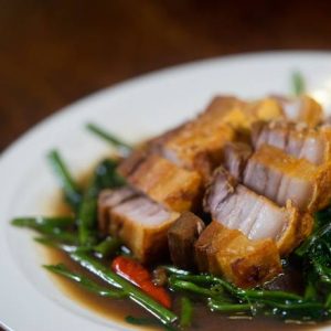 Stir fried Asian water spinach with garlic, chilli, topped with crispy pork belly.